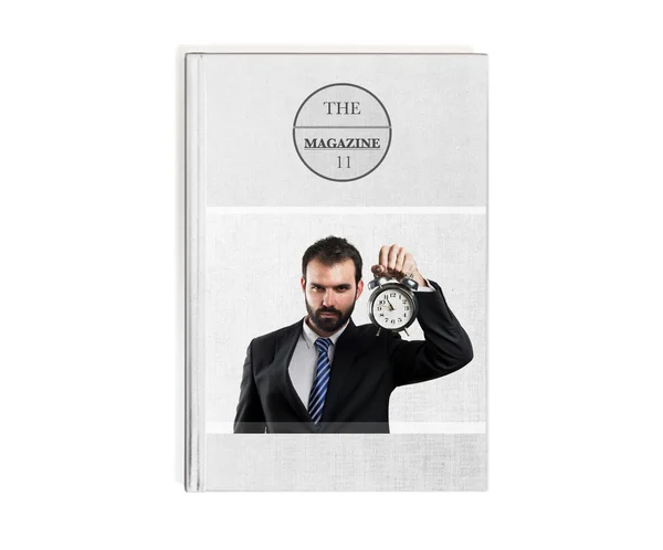 Молодой бизнесмен держит в руках старинные часы, напечатанные на книге — стоковое фото