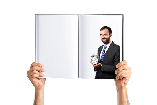 Mladý podnikatel drží starožitné hodiny na knihu — Stock fotografie