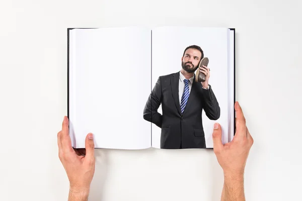 Jonge zakenman praten met zijn schoen afgedrukt op boek — Stockfoto