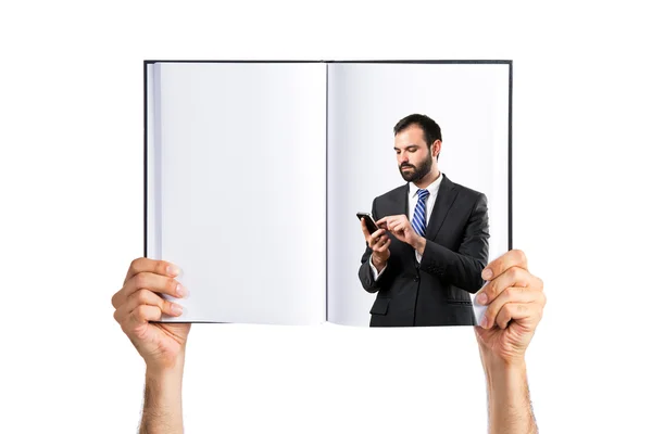 Affärsman som sänder ett budskap tryckt på bok — Stockfoto