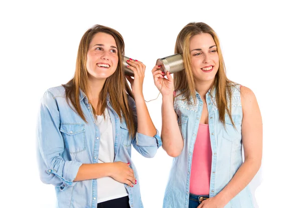 Amigos falando através de um telefone de lata sobre fundo branco — Fotografia de Stock