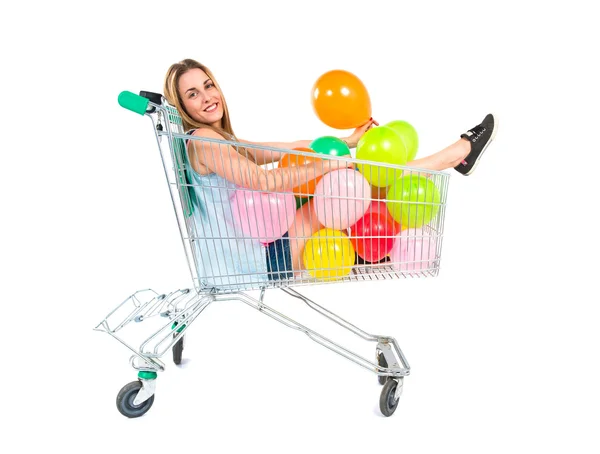 Loira menina bonita dentro de carrinho de supermercado — Fotografia de Stock