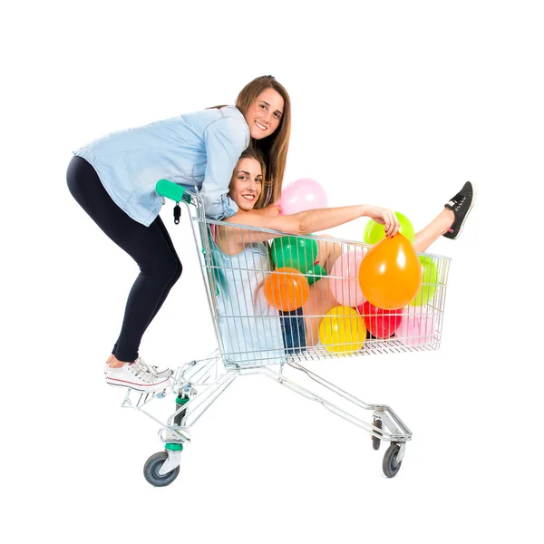 Amigos brincando com balões e carrinho de supermercado — Fotografia de Stock