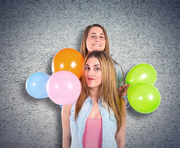 Freunde mit vielen Luftballons vor strukturiertem Hintergrund — Stockfoto