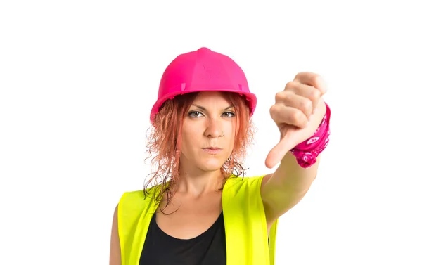 Worker woman doing a bad signal over white background — Stock Photo, Image