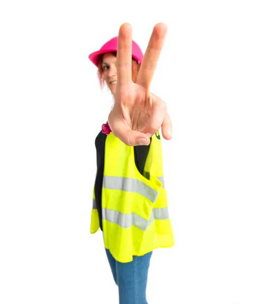 Trabalhador mulher fazendo gesto de vitória sobre fundo branco — Fotografia de Stock
