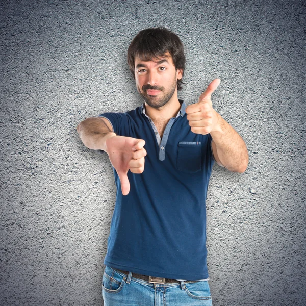 Hombre haciendo una mala señal sobre fondo texturizado —  Fotos de Stock