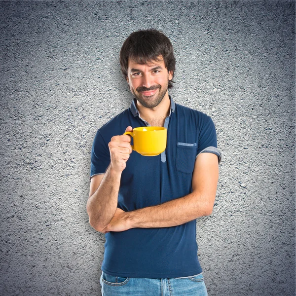Muž, který držel šálek kávy na podklad s texturou — Stock fotografie
