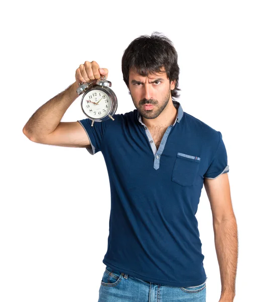 Hombre sosteniendo un reloj sobre fondo blanco — Foto de Stock