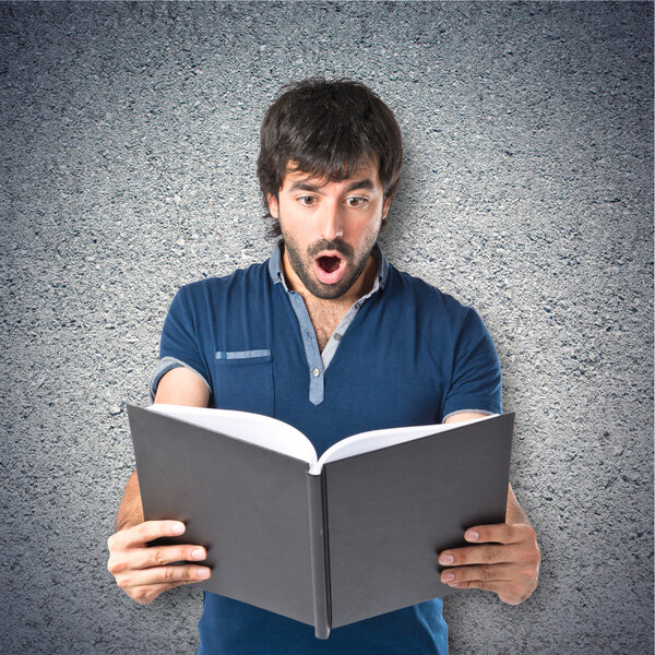 Man reading a book over textured background 