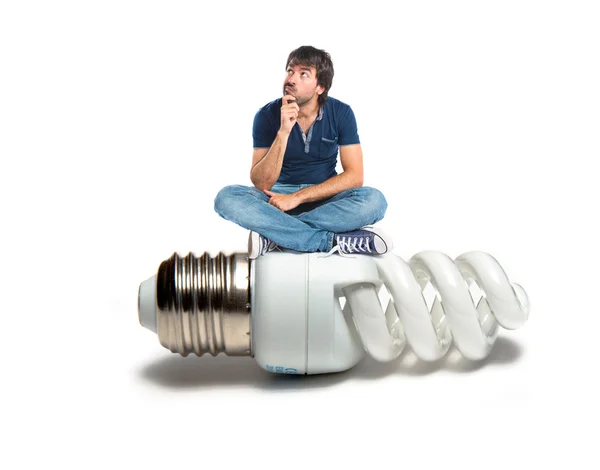 Man thinking on bulb over white background — Stock Photo, Image