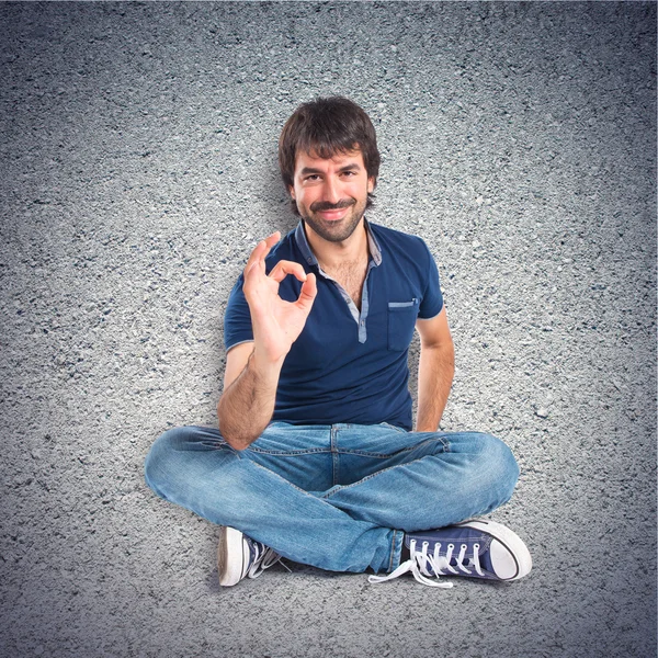 Hombre haciendo Ok signo sobre fondo texturizado —  Fotos de Stock