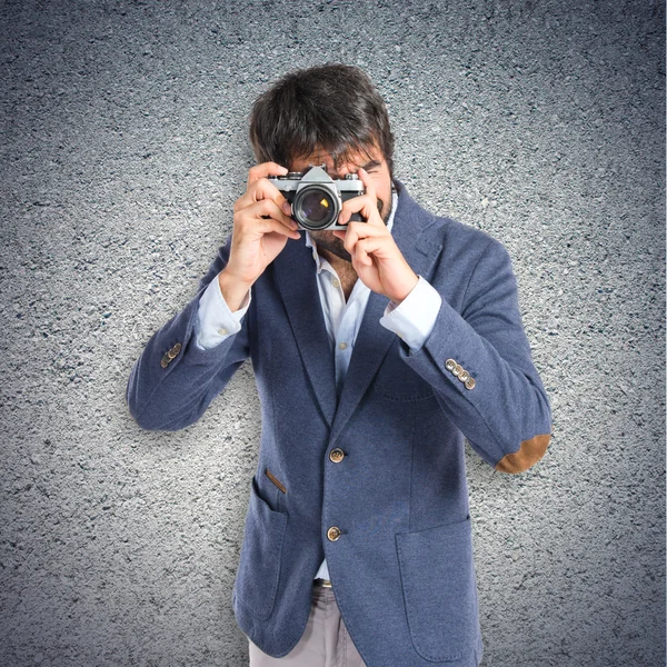 Hombre fotografiando sobre fondo texturizado — Foto de Stock
