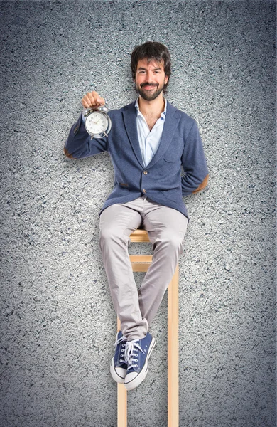 Hombre sosteniendo un reloj sobre fondo texturizado —  Fotos de Stock