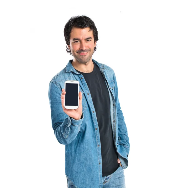 Homem mostrando seu celular sobre fundo branco — Fotografia de Stock