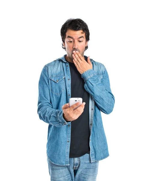 Surprised man talking to mobile over white background — Stock Photo, Image