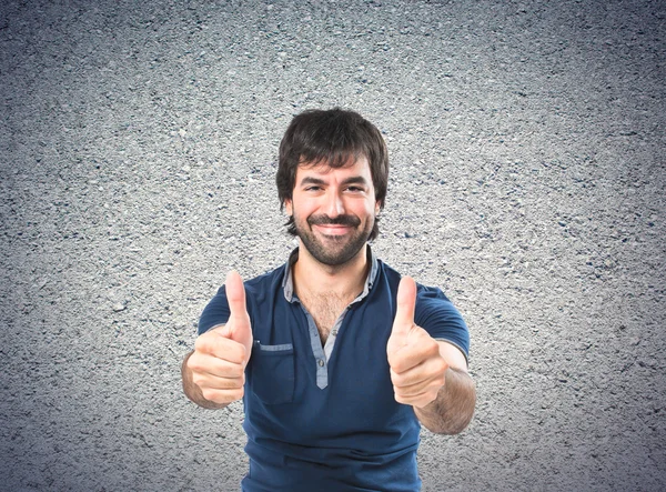 Man with thumb up over textured background — Stock Photo, Image