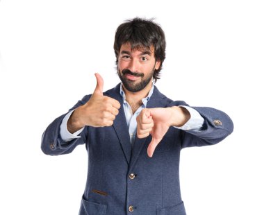 Yakışıklı adam beyaz arka plan üzerinde bir iyi-kötü işaret yapma