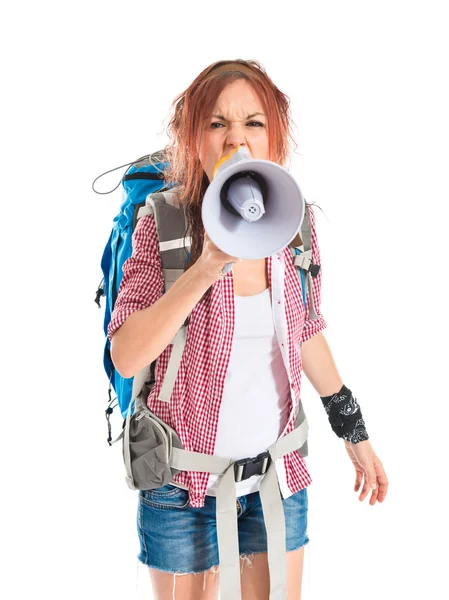 Backpacker shouting by megaphone over white background — Stock Photo, Image