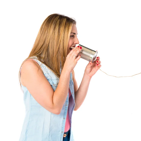 Ragazza parlando attraverso un telefono di latta su sfondo bianco — Foto Stock