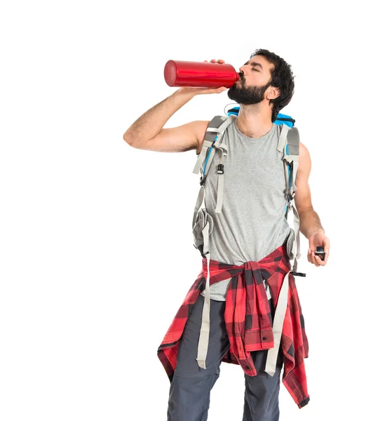 Backpacker trinkt Wasser vor weißem Hintergrund — Stockfoto