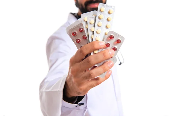 Medico in possesso di pillole su sfondo bianco — Foto Stock