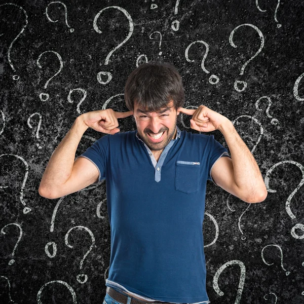 Hombre cubriéndose las orejas sobre fondo texturizado — Foto de Stock