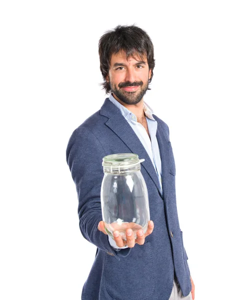Bonito homem segurando um frasco de vidro vazio sobre fundo isolado — Fotografia de Stock