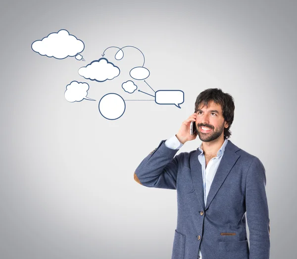 Hombre guapo hablando con móvil sobre fondo gris —  Fotos de Stock