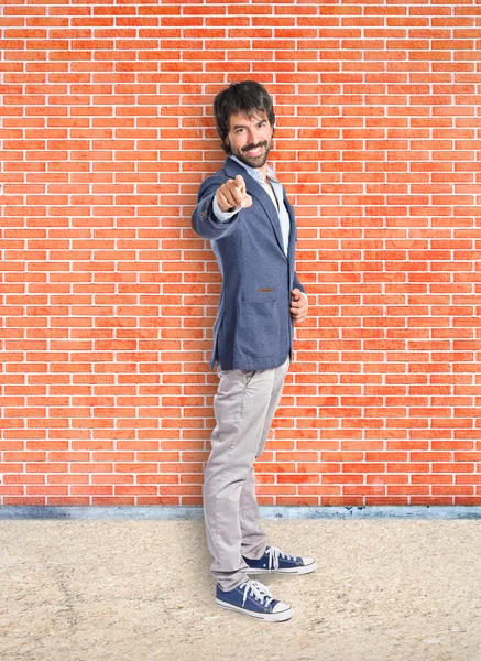 Businessman pointing to the front over textured background — Stock Photo, Image