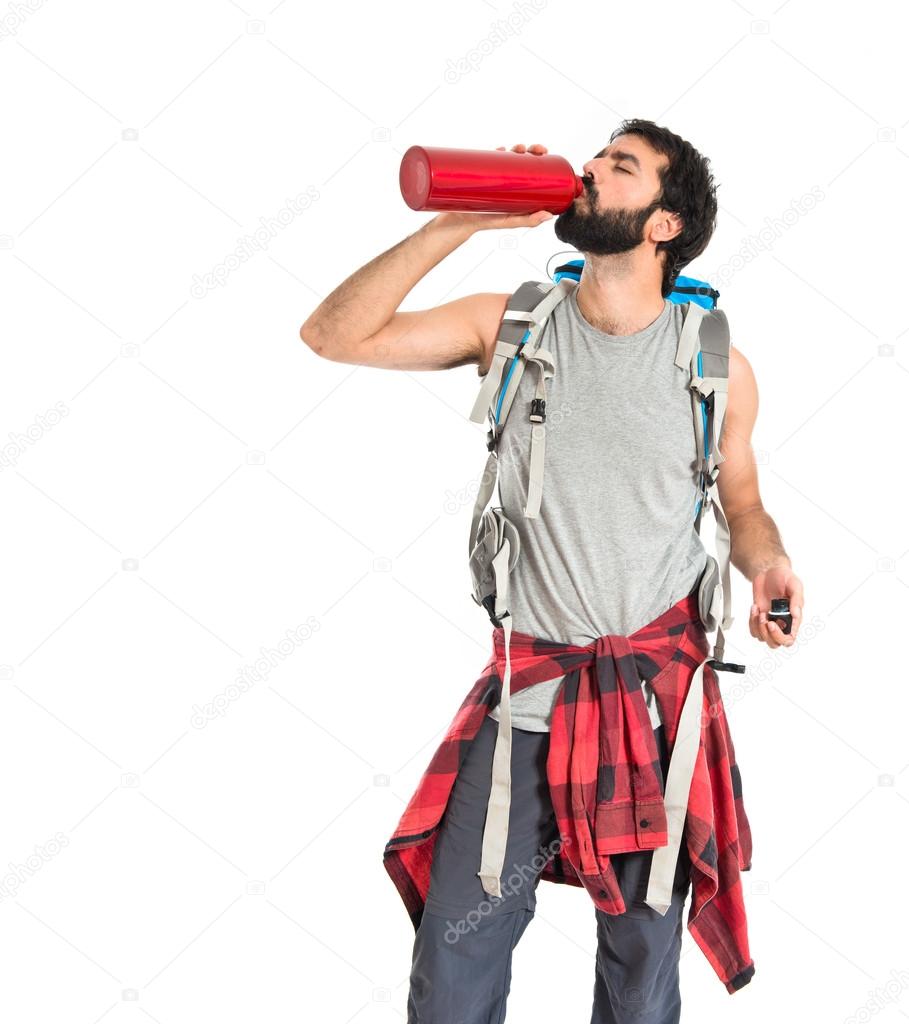 Backpacker drinking water over white background