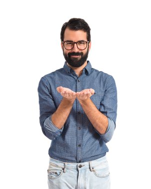 Bir şey beyaz arka plan üzerinde tutan genç hipster adam  