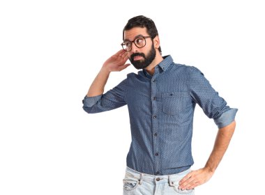Beyaz arka plan üzerinde dinleme genç hipster adam 