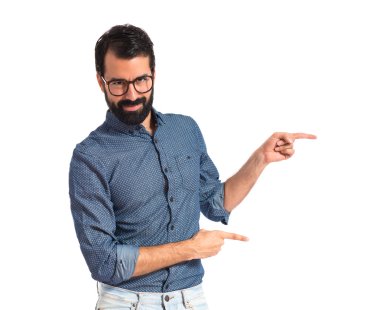 Genç hipster adam işaret lateral beyaz arka plan üzerinde