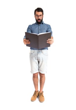 Şaşırmış hippi adam kitap okuyor.