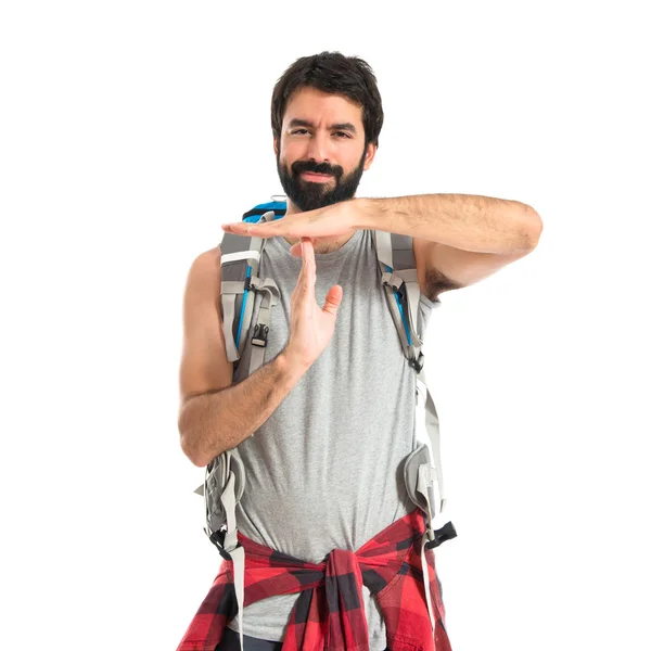Backpacker making time out gesture over white background — Stockfoto