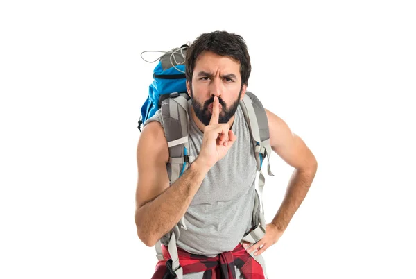 Backpacker making silence gesture over isolated white background — Stock Photo, Image