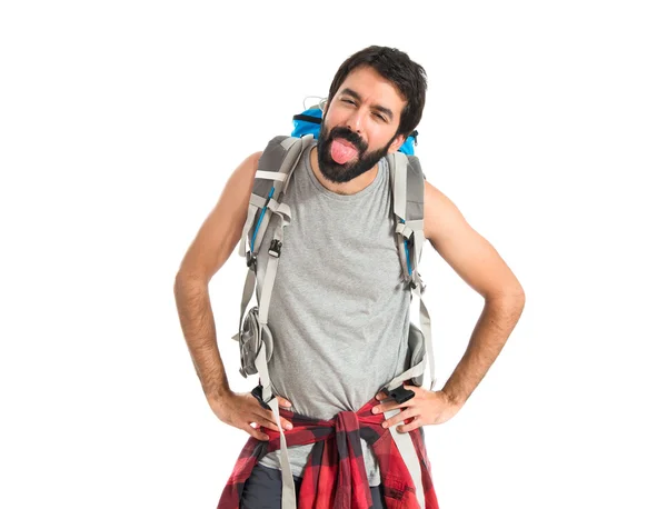 Backpacker doing a joke over isolated white background — Stockfoto