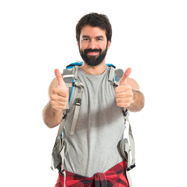 Mochileiro com polegar para cima sobre fundo branco — Fotografia de Stock