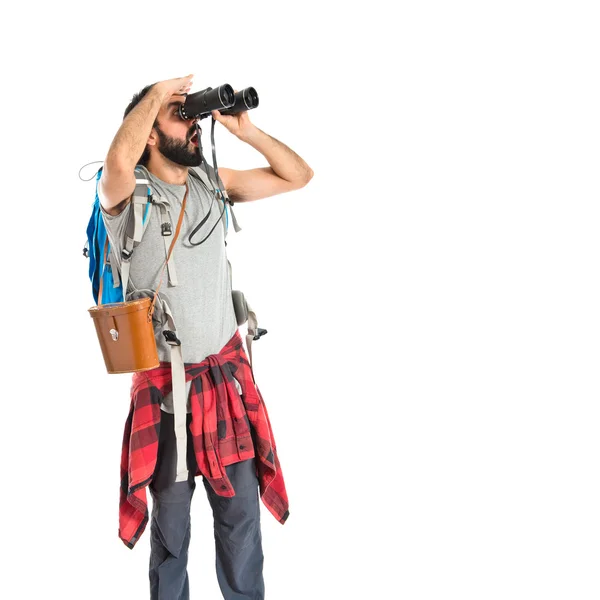 Backpacker with binoculars over isolated white background — Stock Photo, Image