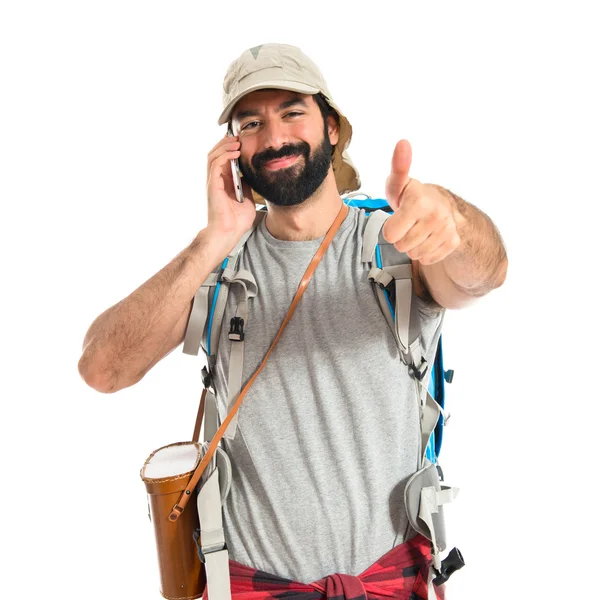 Backpacker spricht mit Handy über weißem Hintergrund — Stockfoto