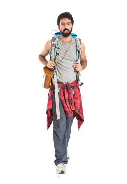 Young backpacker walking over white background — Stock Photo, Image