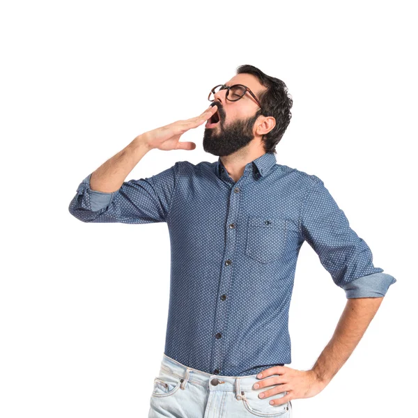 Junger Hipster-Mann gähnt vor weißem Hintergrund — Stockfoto