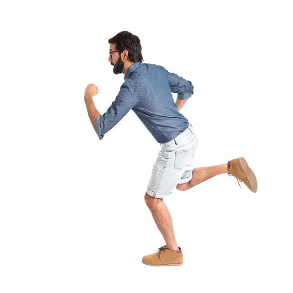 Junger Hipster-Mann läuft schnell über weißen Hintergrund — Stockfoto