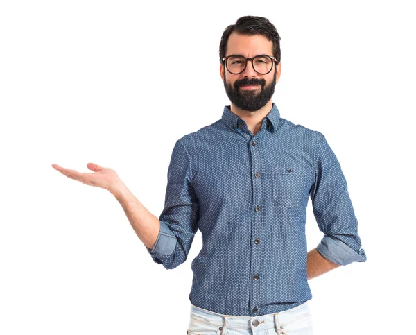 Joven hipster hombre sosteniendo algo sobre fondo blanco —  Fotos de Stock