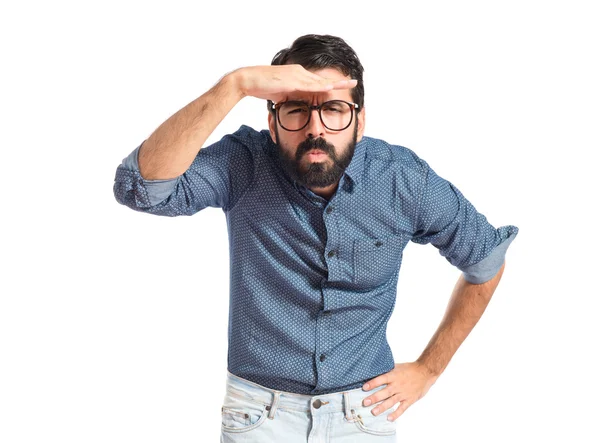 Joven hipster hombre mostrando algo sobre fondo blanco — Foto de Stock