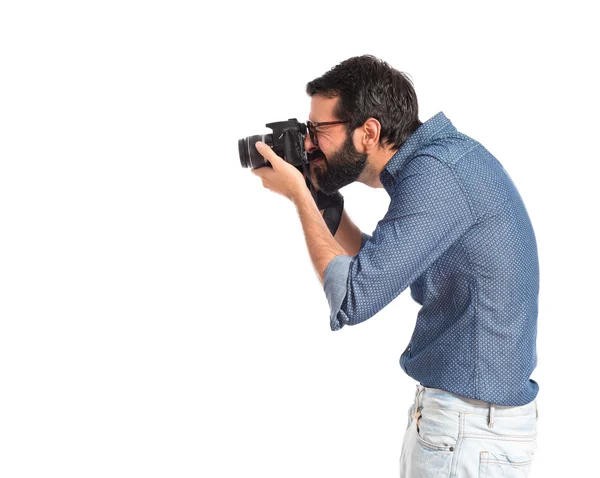Молодой хипстер фотографирует на белом фоне — стоковое фото