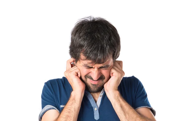 Hombre cubriéndose las orejas sobre fondo blanco — Foto de Stock