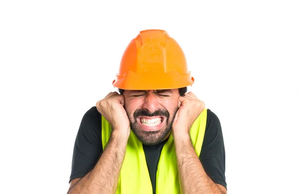 Obrero cubriéndose las orejas sobre fondo blanco — Foto de Stock