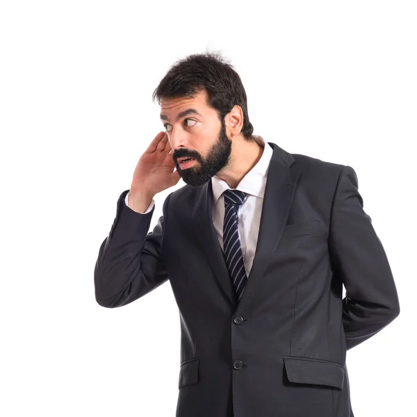 Businessman listening over isolated white background — Stock Photo, Image